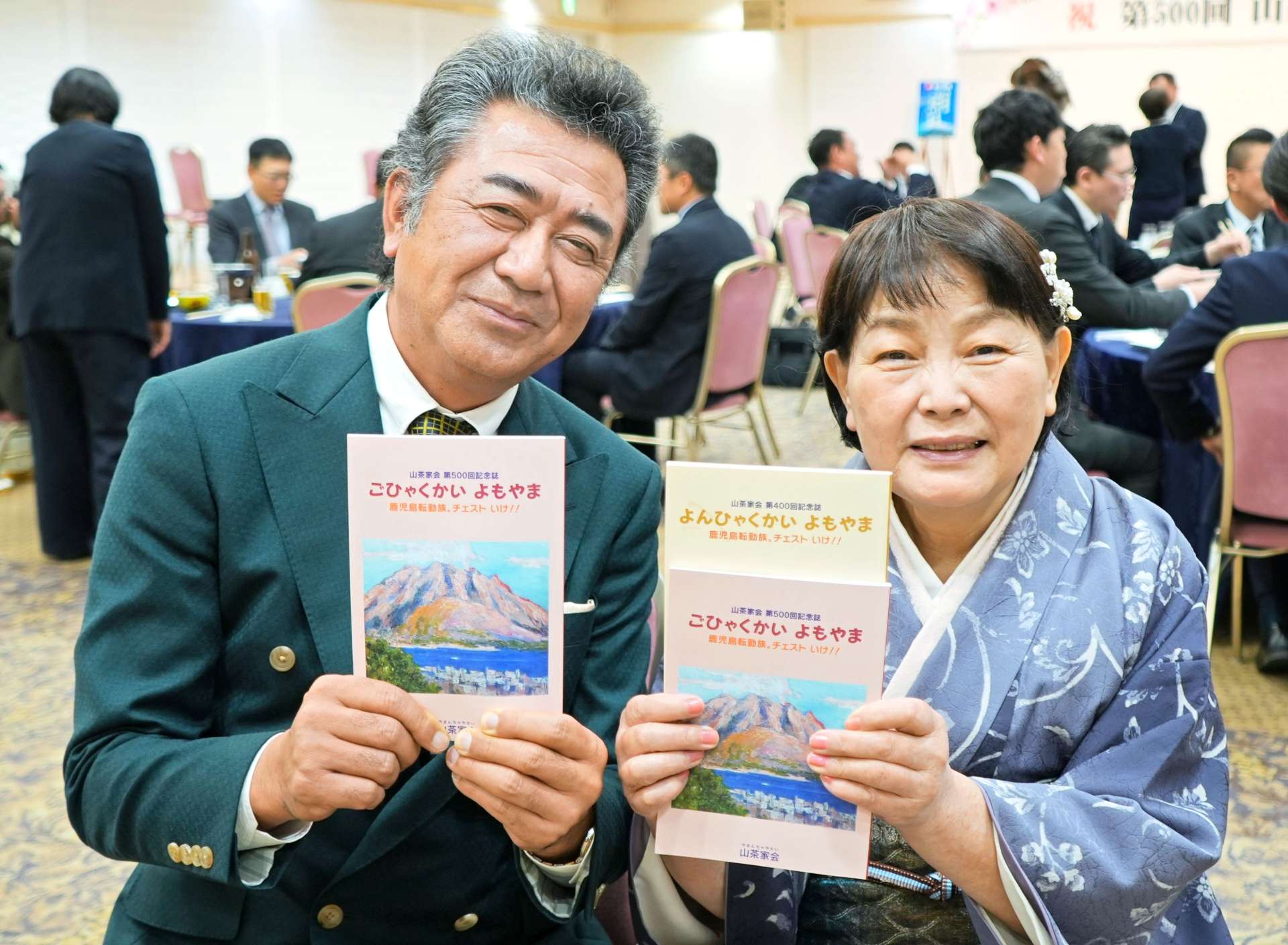 ５００回記念誌を手にする宮澤章会長（左）と４００回と５００回の記念誌を持つ福重リイ子さん＝１７日、鹿児島市