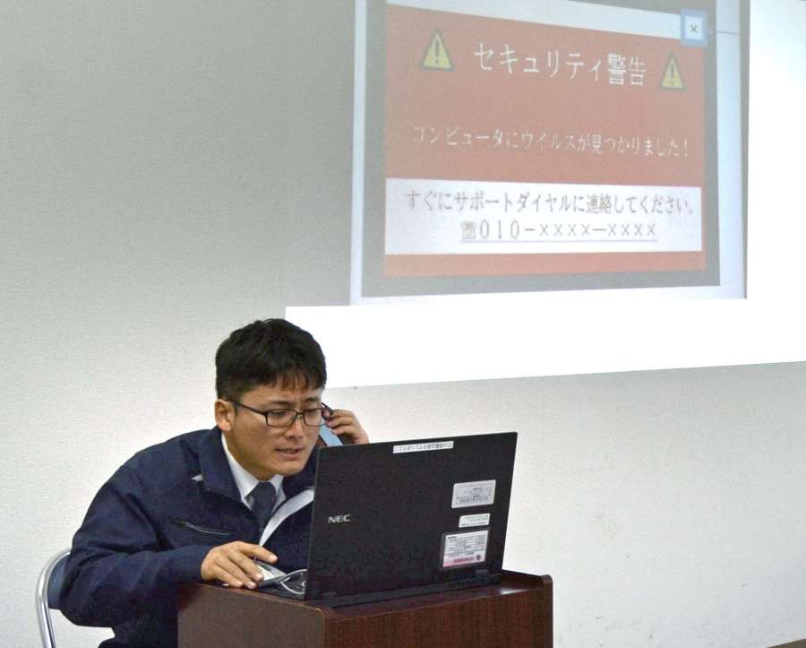 寸劇で、パソコンサポート詐欺にだまされる様子を再現する阿久根警察署員＝阿久根市の同署