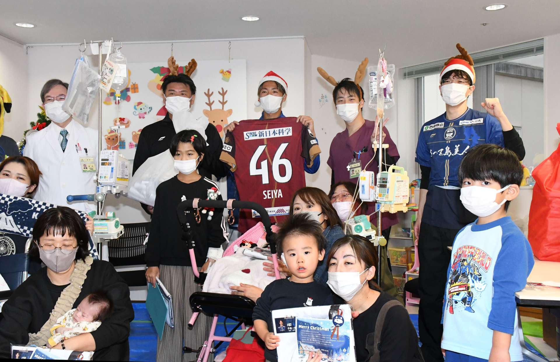 クリスマスプレゼントを届け、記念撮影する鹿児島Ｕの武星弥選手（中央）ら＝１８日、鹿児島市立病院