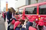 郵便配達用の車両を飾り付ける「かのやカンパチロウ」と白崎保育園児＝鹿屋市白崎町