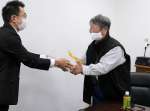 「ふるさとお楽しみ便」を受け取る星塚敬愛園の山口文夫自治会長＝１７日、鹿屋市星塚町
