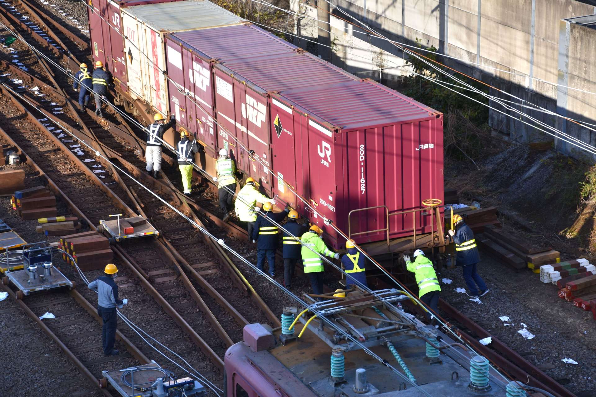 貨車を押して移動させる作業員ら＝１９日午後３時４０分ごろ、薩摩川内市の川内駅付近