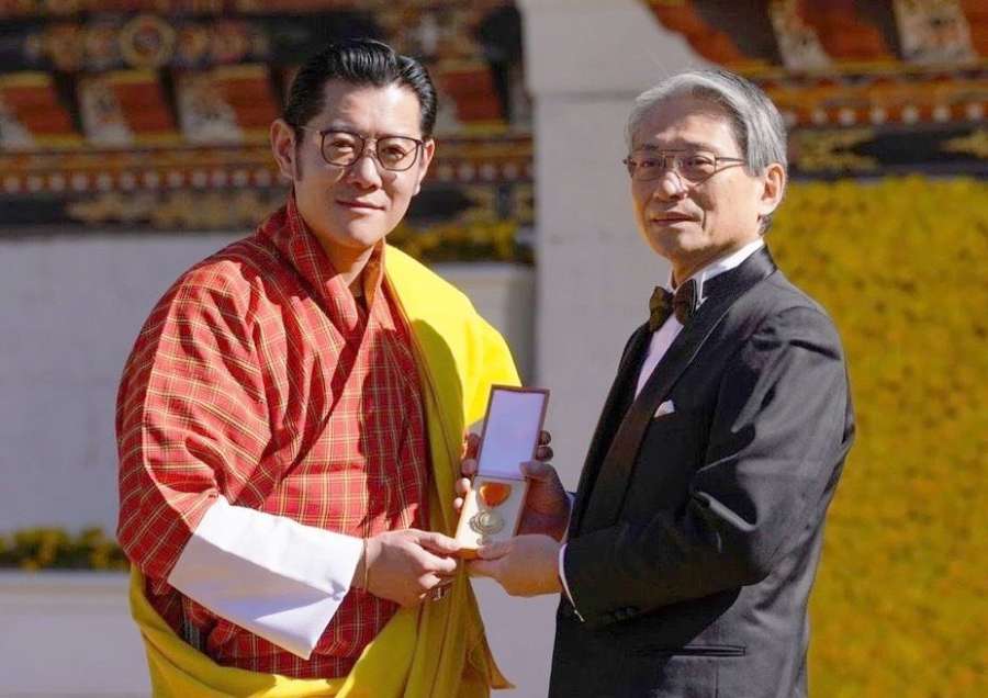 ワンチュク国王（左）から国家功労勲章一等金メダルを受けた永田良一会長兼社長＝ブータンの首都ティンプー（新日本科学提供）