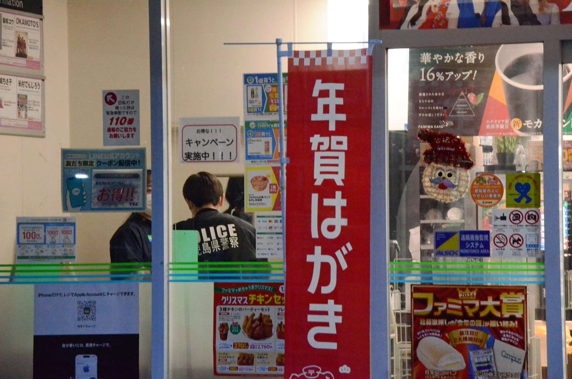 （別カット）強盗現場のコンビニを調べる警察官＝２２日午前７時２０分ごろ、鹿児島市上之園町