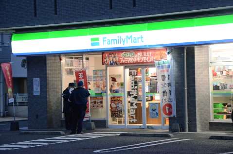 強盗現場のコンビニを調べる警察官＝２２日午前７時１５分、鹿児島市上之園町