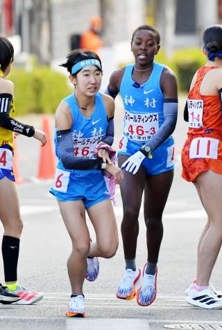 〈関連〉第３中継所、神村のムトニ（右）が黒神にたすきをつなぐ＝京都市