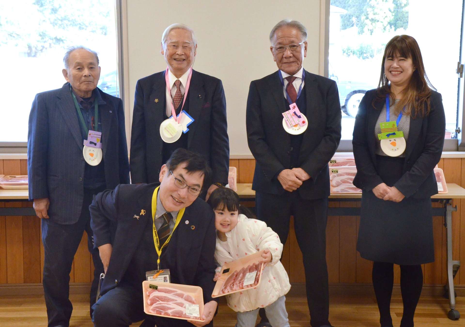 かごしま黒豚を贈った県食肉公正取引協議会の肥後辰彦会長（後列中央左）ら＝２３日、鹿児島市の仁風学園