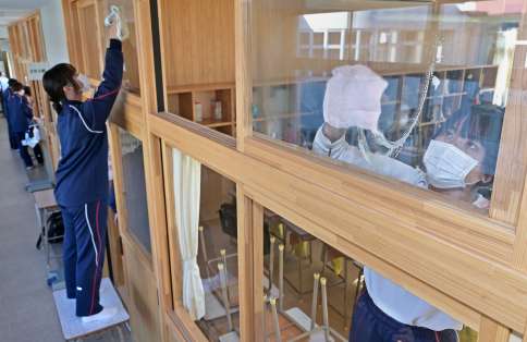 高い窓も一枚一枚きれいに吹き上げる生徒たち＝２４日午前、鹿児島市の武岡台高校