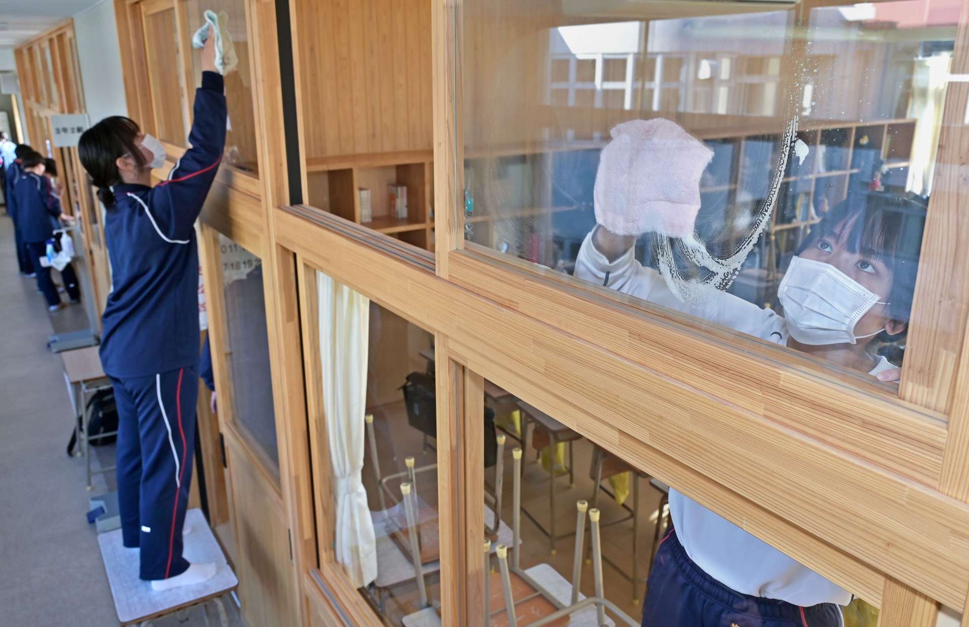 高い窓も一枚一枚きれいに吹き上げる生徒たち＝２４日午前、鹿児島市の武岡台高校