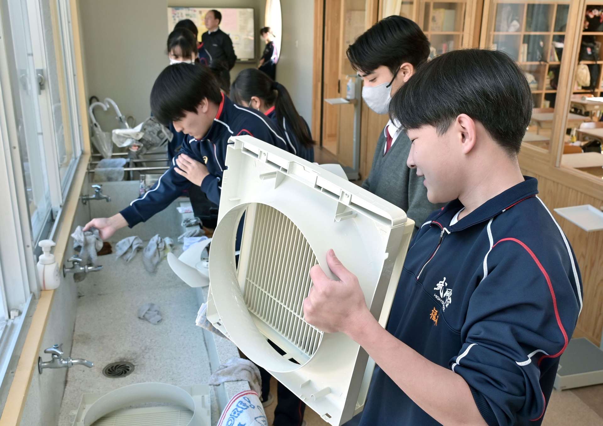 １年の汚れを丁寧に落とす生徒たち＝２４日午前、鹿児島市の武岡台高校