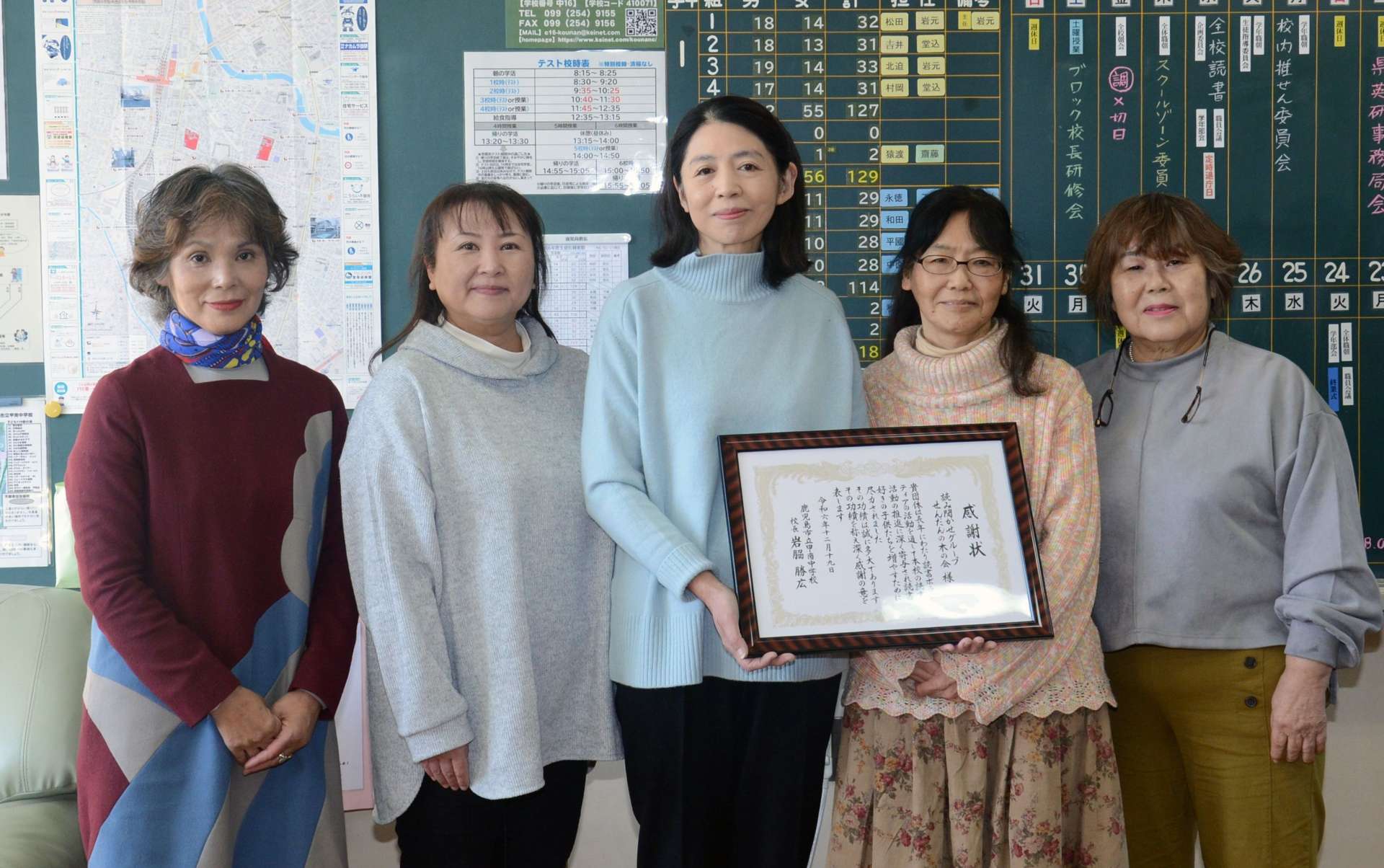 長年の読み聞かせ活動に対して甲南中学校長から感謝状を贈呈された「せんだんの木の会」の会員＝鹿児島市高麗町の甲南中学校