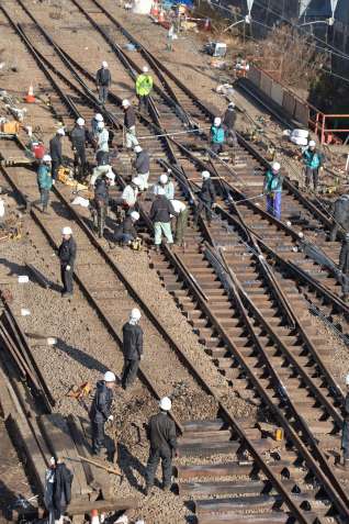 （別カット）脱線現場でレールや枕木の復旧に当たる作業員ら＝２５日午前１０時１０分ごろ、薩摩川内市の川内駅付近
