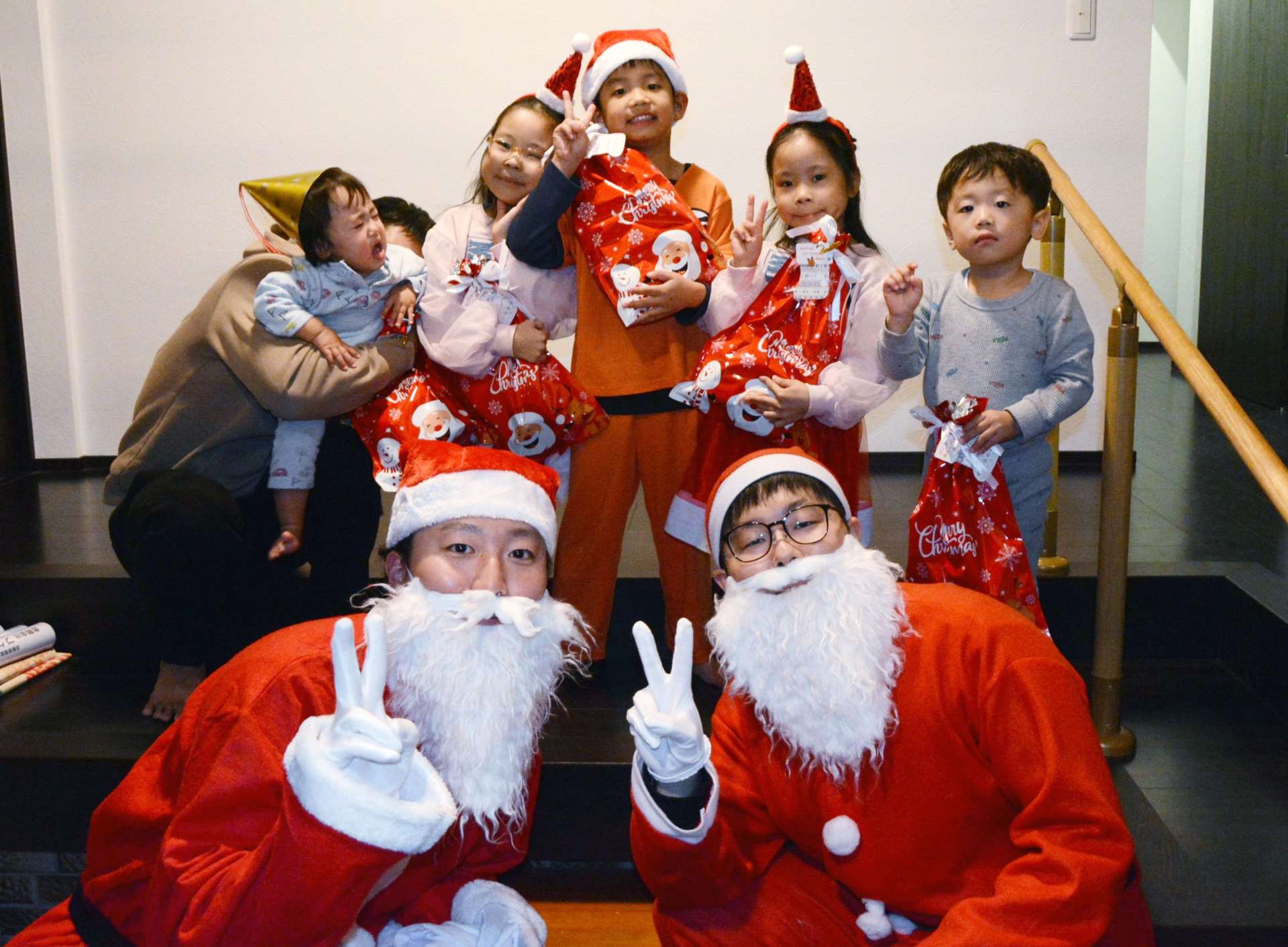 サンタクロースと記念写真を撮る子どもたち＝２４日、さつま町山崎