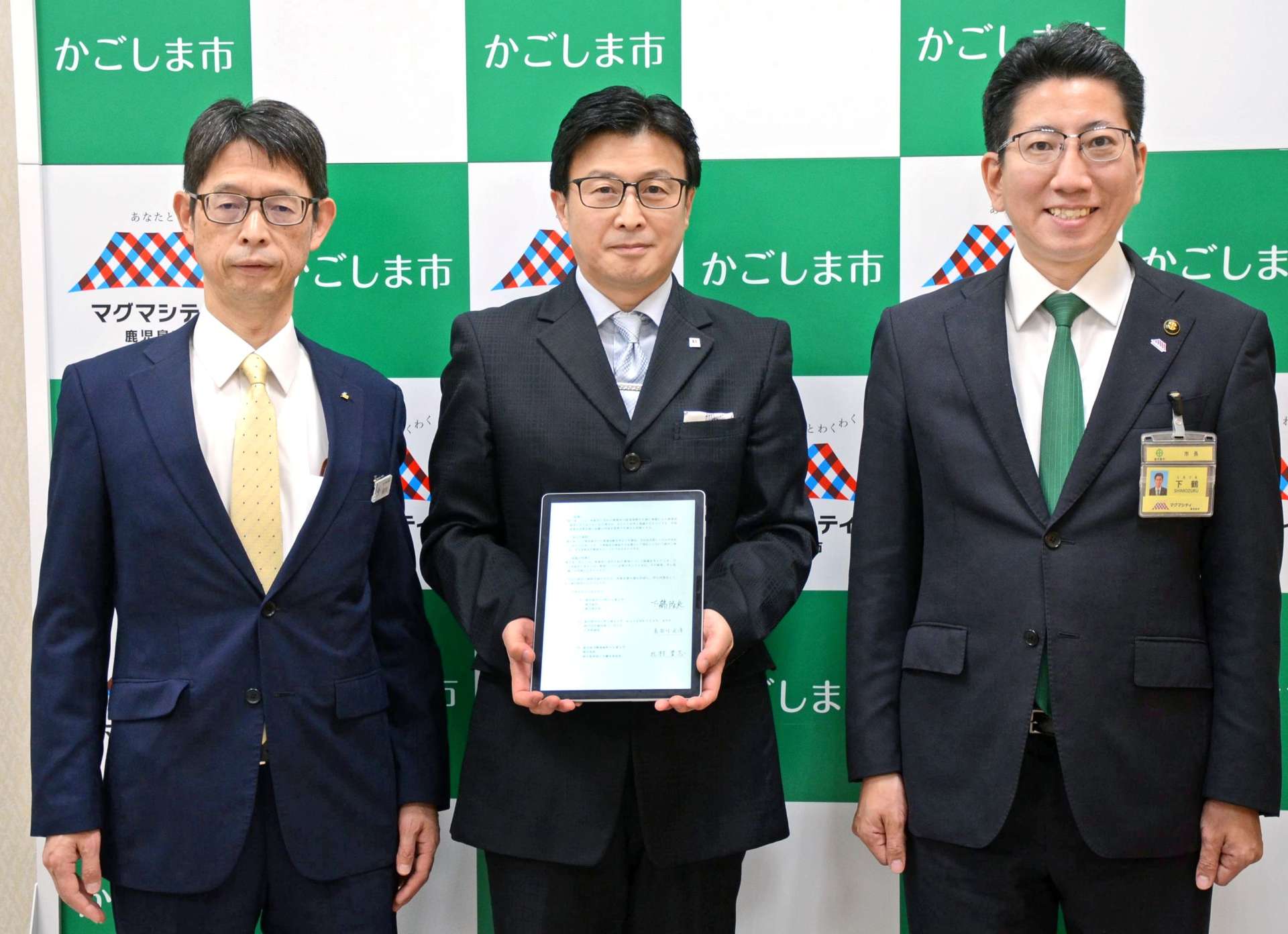 立地協定を結んだ鹿児島インサイトの長谷川光洋社長（中央）＝２６日、鹿児島市役所
