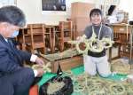 能登半島地震の被災者に贈るしめ縄を作る福田典子さん（右）＝伊佐市役所