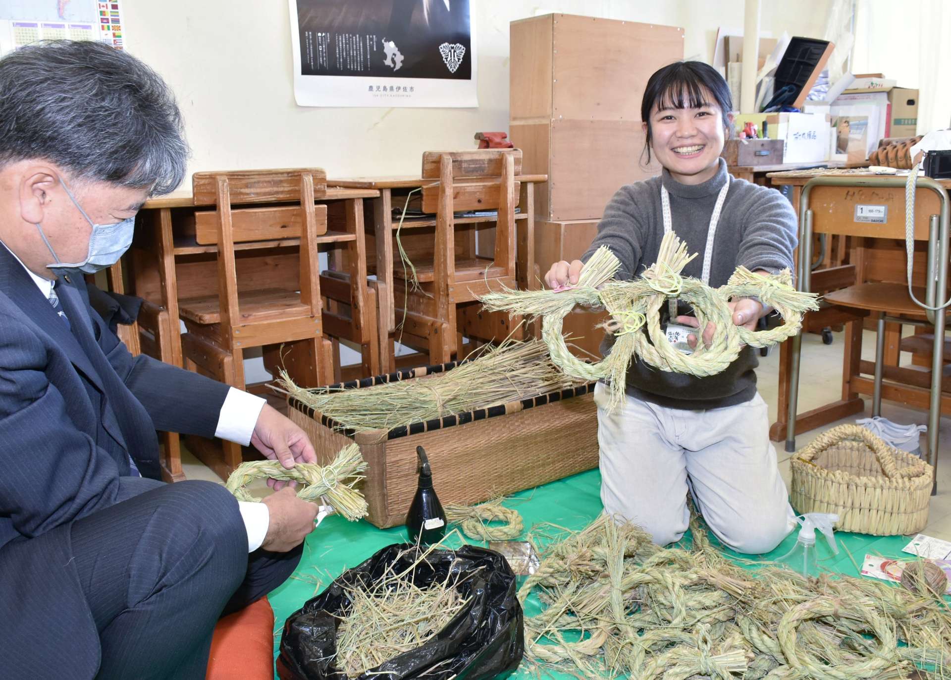 能登半島地震の被災者に贈るしめ縄を作る福田典子さん（右）＝伊佐市役所