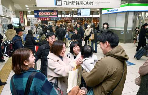 改札口付近で再会を喜ぶ家族連れ＝２８日、鹿児島市のＪＲ鹿児島中央駅