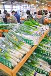 〈別カット〉年末年始の買い出しで混雑する店内。鍋物に欠かせないネギも高めだった＝２７日、鹿児島市のおいどん市場与次郎館