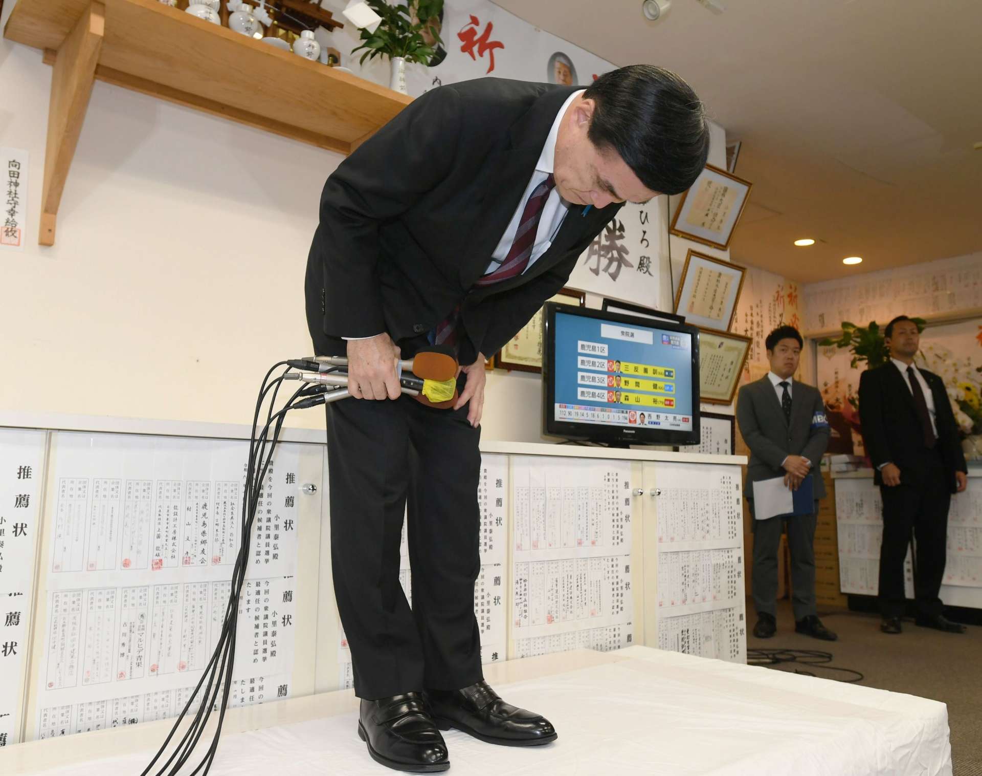 落選確実の報を受け、支援者らに頭を下げる小里泰弘さん＝１０月２７日、薩摩川内市