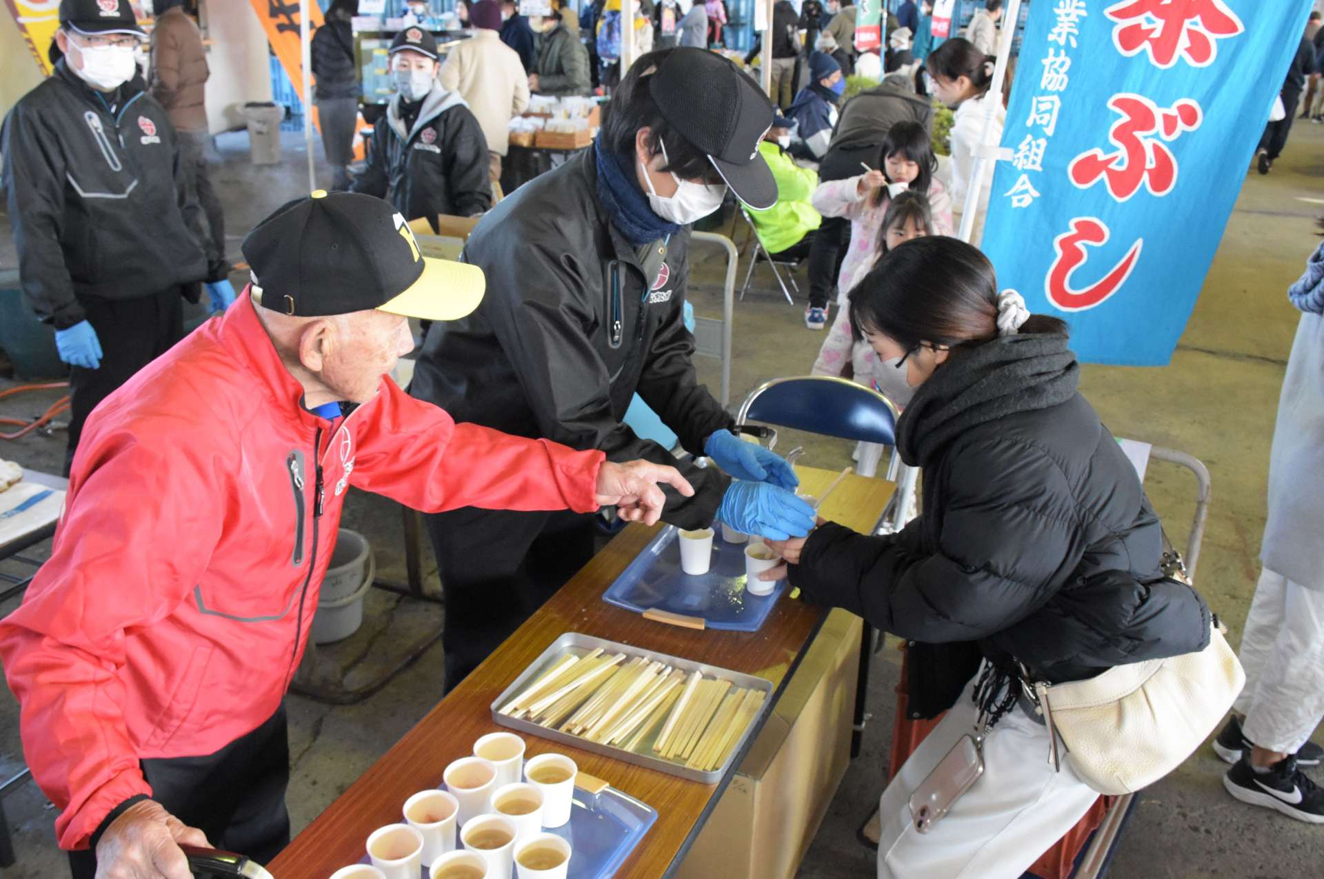 買い物客に茶ぶしを振る舞う関係者＝２９日、指宿市の山川町漁協水揚げ場