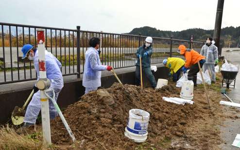 ９月の豪雨で堆積した土砂を片付ける災害ボランティア＝１６日、石川県珠洲市上戸町