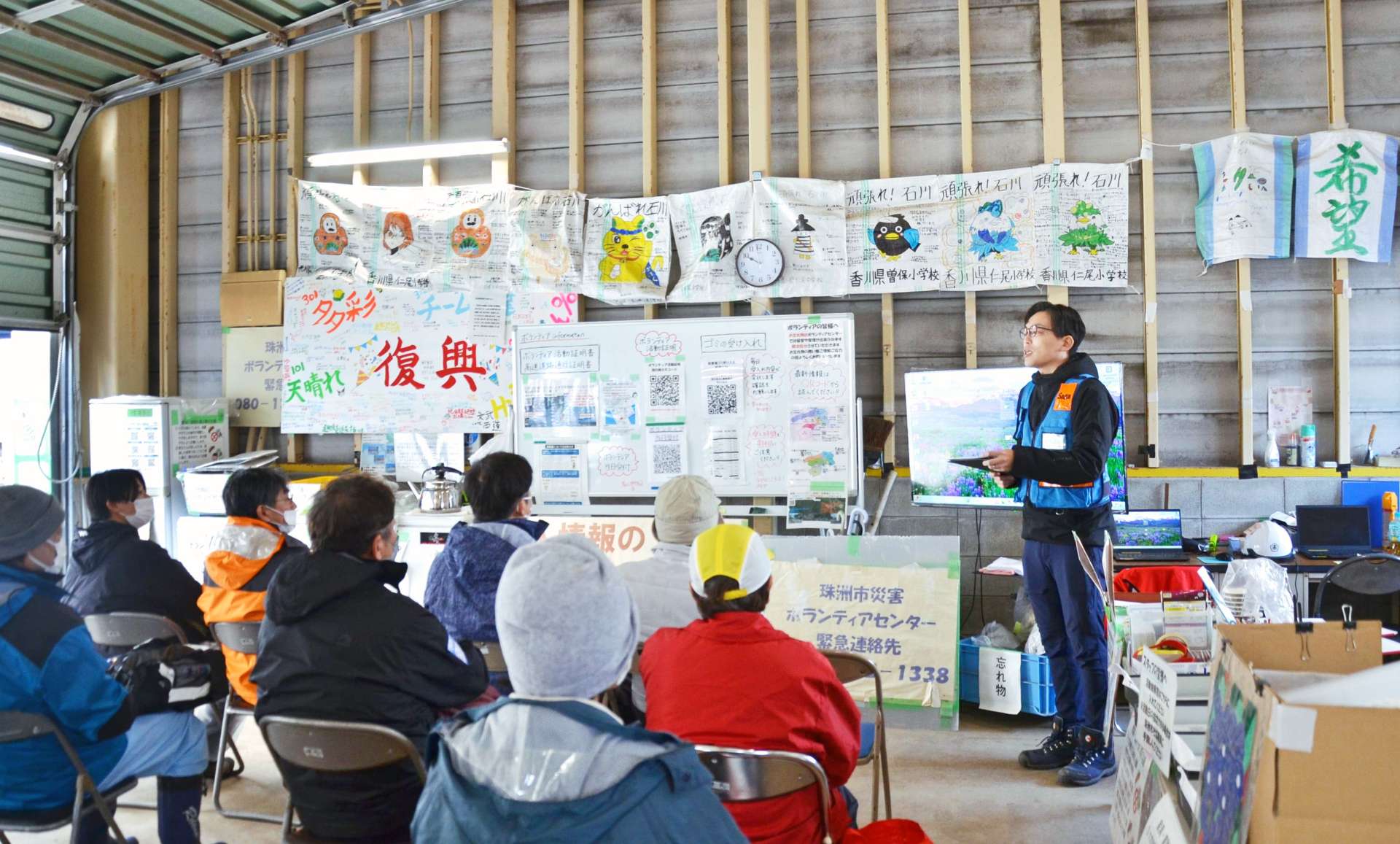 社会福祉協議会の職員に説明を受ける災害ボランティア＝１６日、石川県珠洲市