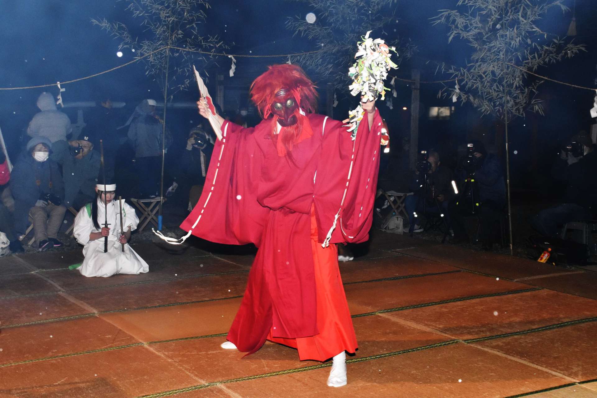 かがり火に照らされた舞台で舞う演者＝１日午前１時半ごろ、薩摩川内市の大宮神社