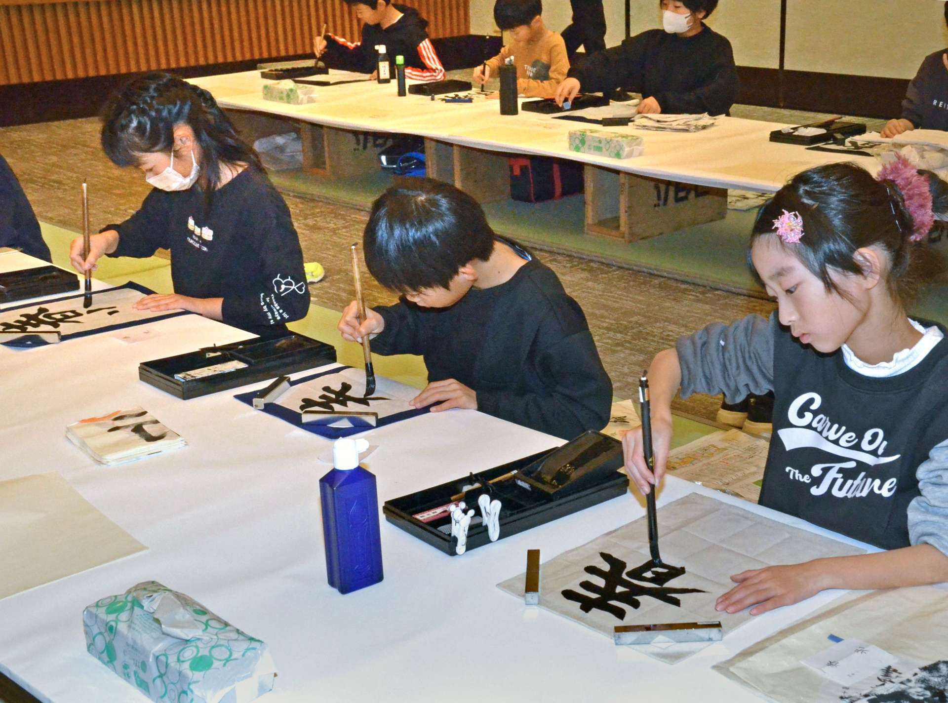 丁寧に筆を運ぶ参加者＝３日、鹿児島市の山形屋