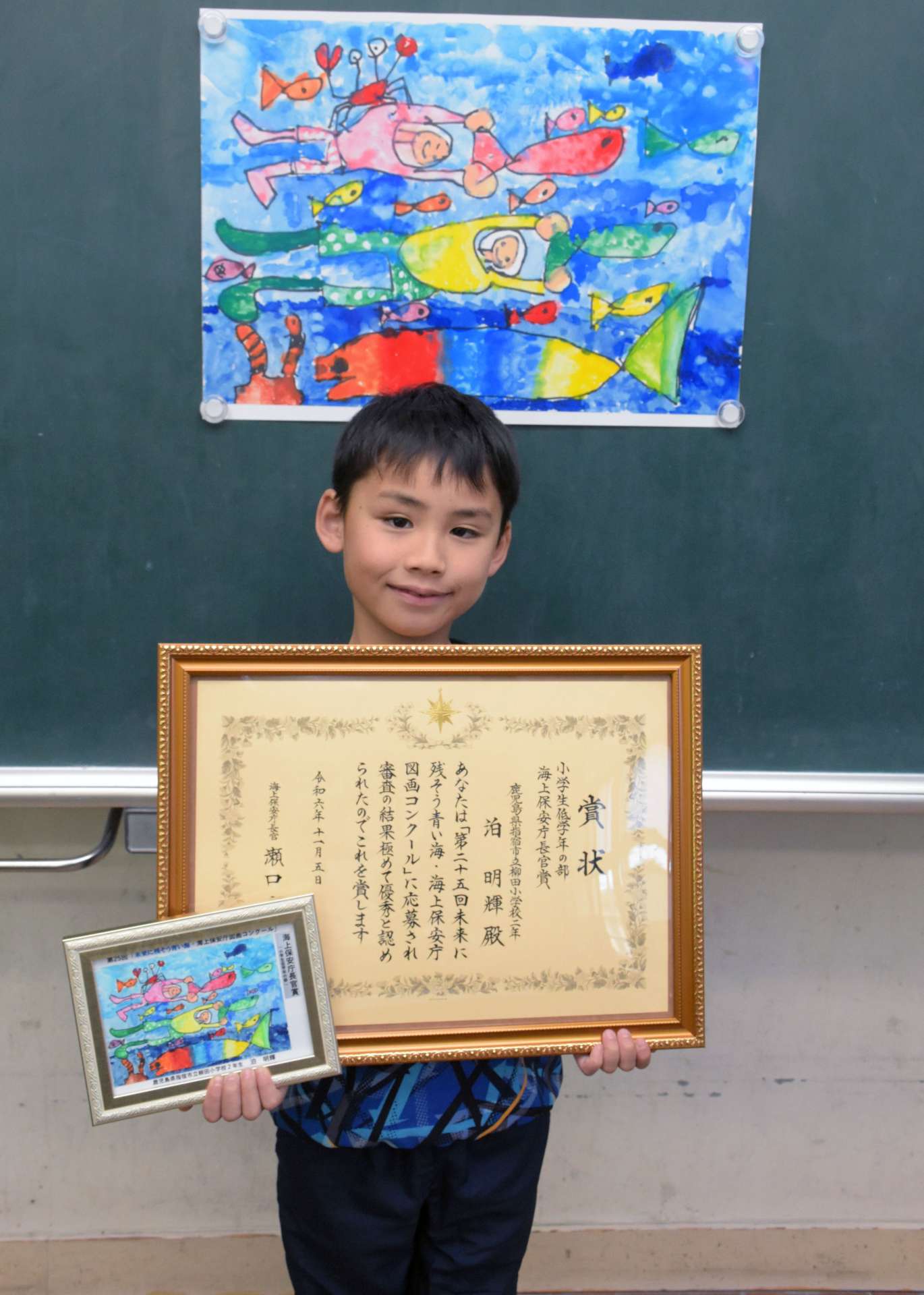 海上保安庁長官賞を受賞し喜ぶ泊明輝さん＝指宿市の柳田小学校