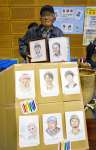 イベント会場で似顔絵を展示する宮内軍吉さん＝阿久根市総合体育館