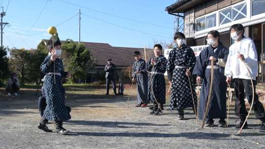 射抜いたミカンを掲げ喜ぶ子ども＝２日、枕崎市桜木町の小江平公民館
