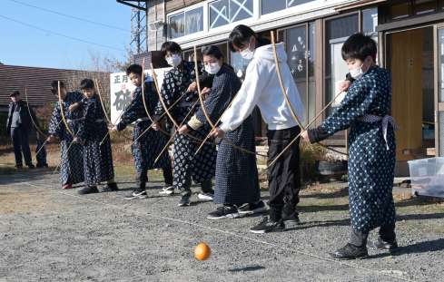 転がる的を狙って矢を放つ子どもたち＝２日、枕崎市桜木町の小江平公民館
