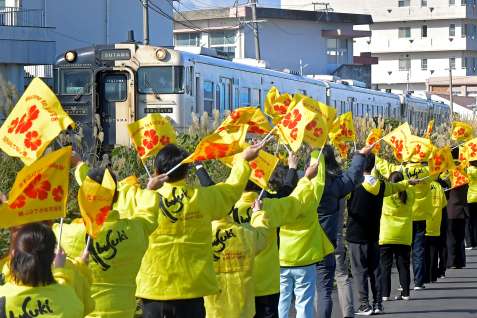 指宿市職員らの歓迎を受け走る観光特急「指宿のたまて箱」＝２０２４年１２月、同市十町