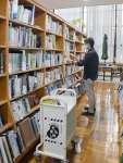 人の少ないタイミングを見て、返却された本を書架に戻す職員＝指宿市の指宿図書館