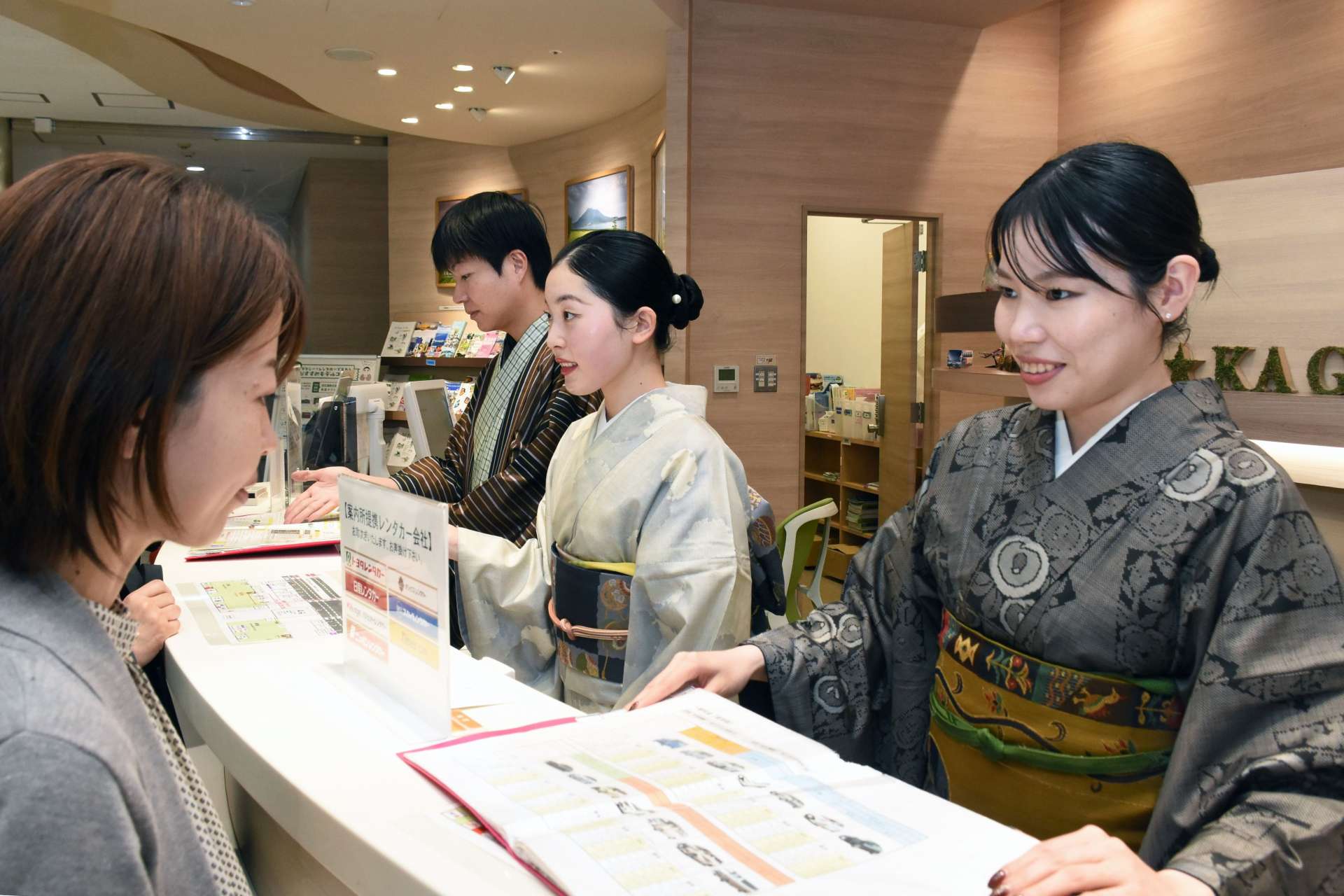 大島紬姿で接客する職員＝６日、霧島市の鹿児島空港