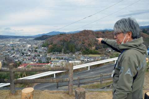 椋鳩十の生家があった場所を示す椋鳩十記念館の木下潤児館長＝２０２４年１２月１３日、長野県喬木村