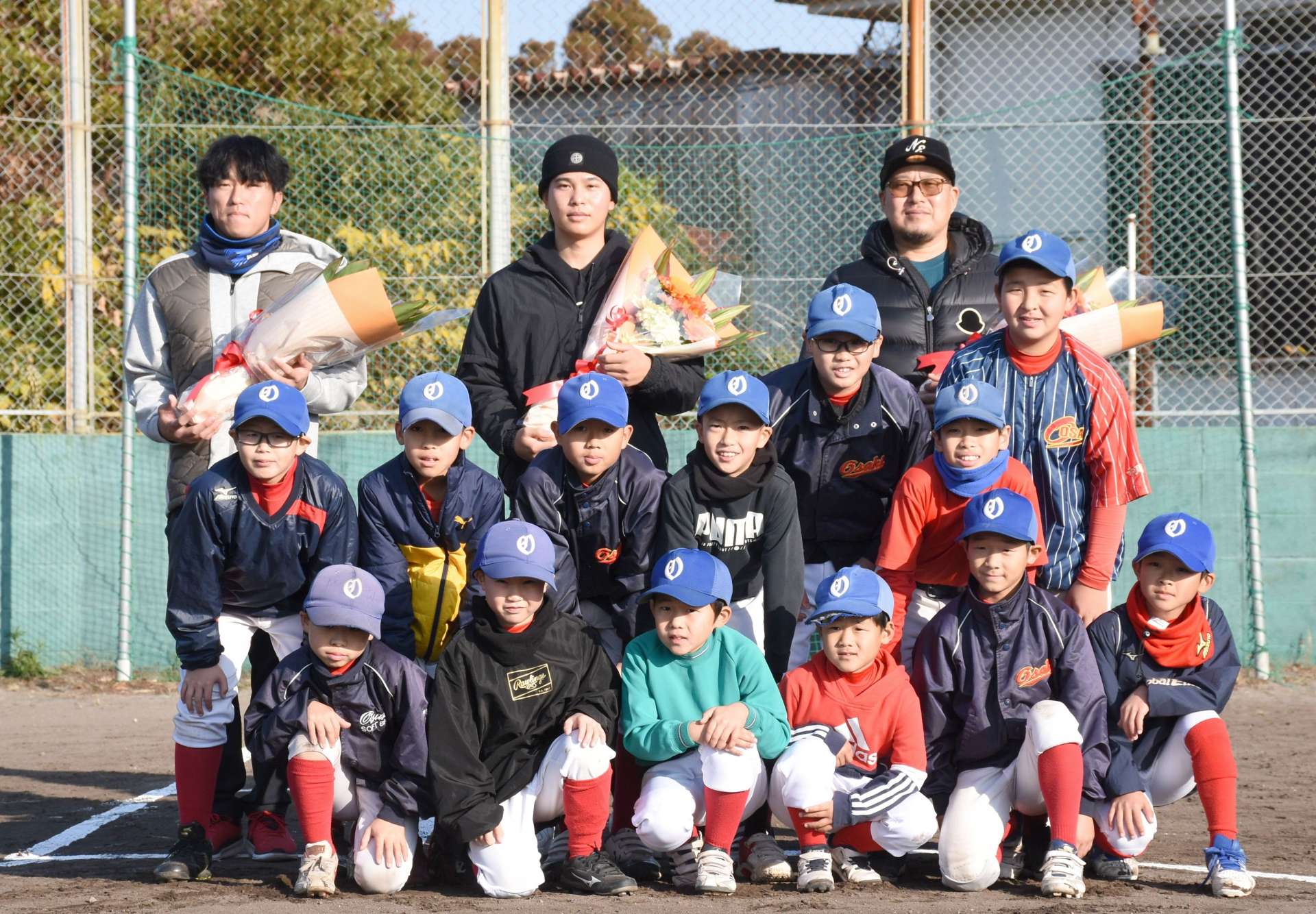松山竜平選手（右）らと記念撮影する大崎ソフトボールスポーツ少年団＝大崎町研修センターグラウンド