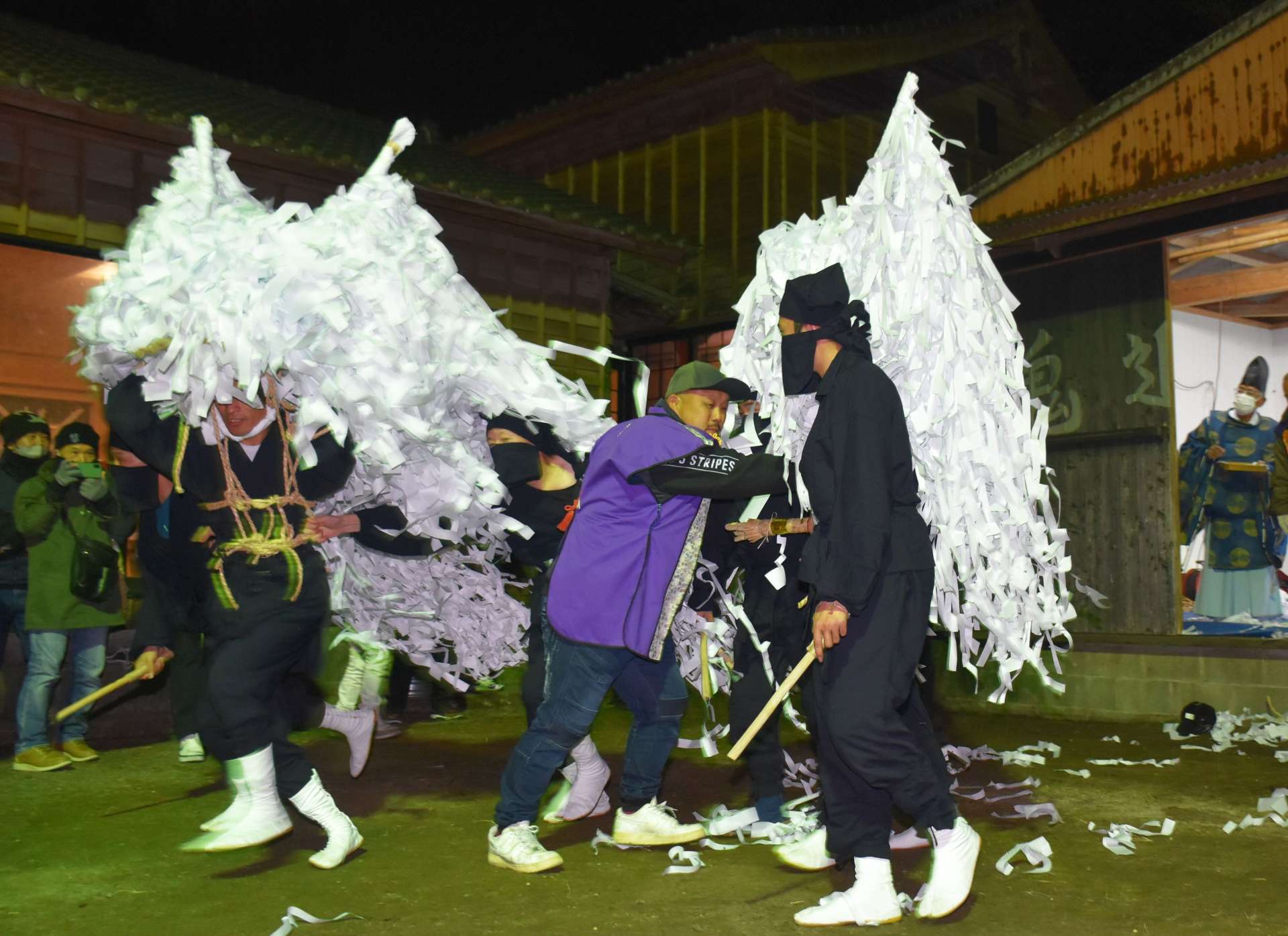 〈関連〉御幣をまとい、鬼堂（右）から躍り出た鬼たち＝７日夜、曽於市末吉の熊野神社