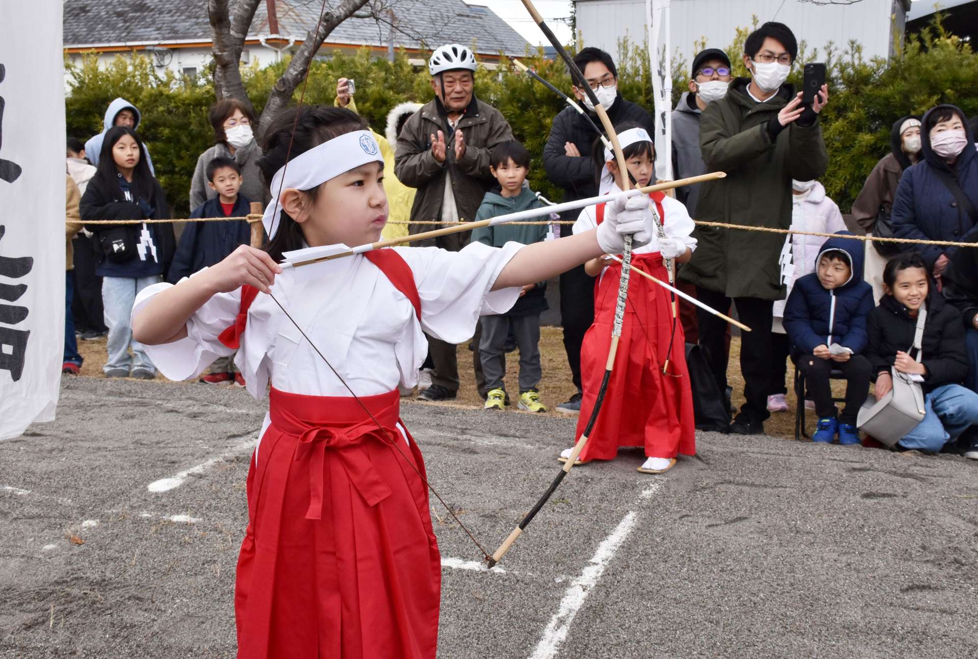 真剣な表情で弓をひく園児ら＝７日、薩摩川内市の新田神社