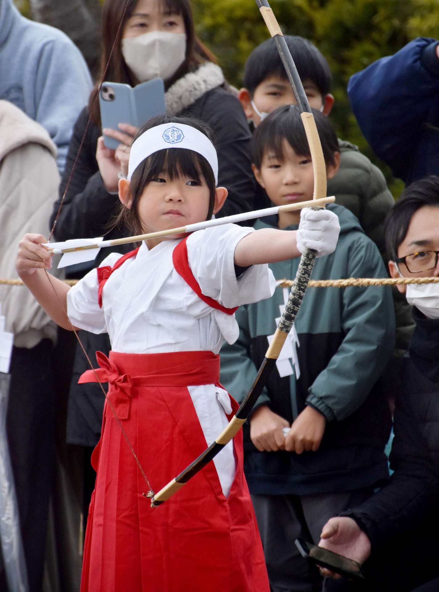 真剣な表情で弓をひく園児＝７日、薩摩川内市の新田神社