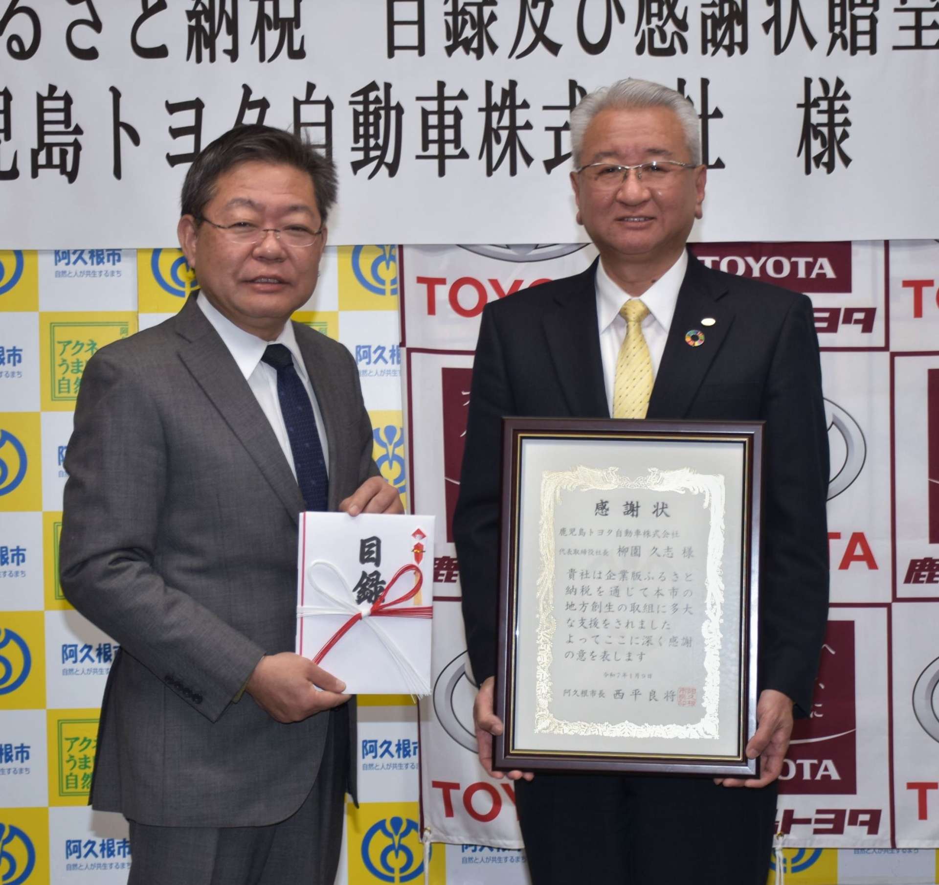 企業版ふるさと納税の目録と感謝状を手にする西平良将・阿久根市長（左）と柳園久志・鹿児島トヨタ自動車社長＝９日、同市役所