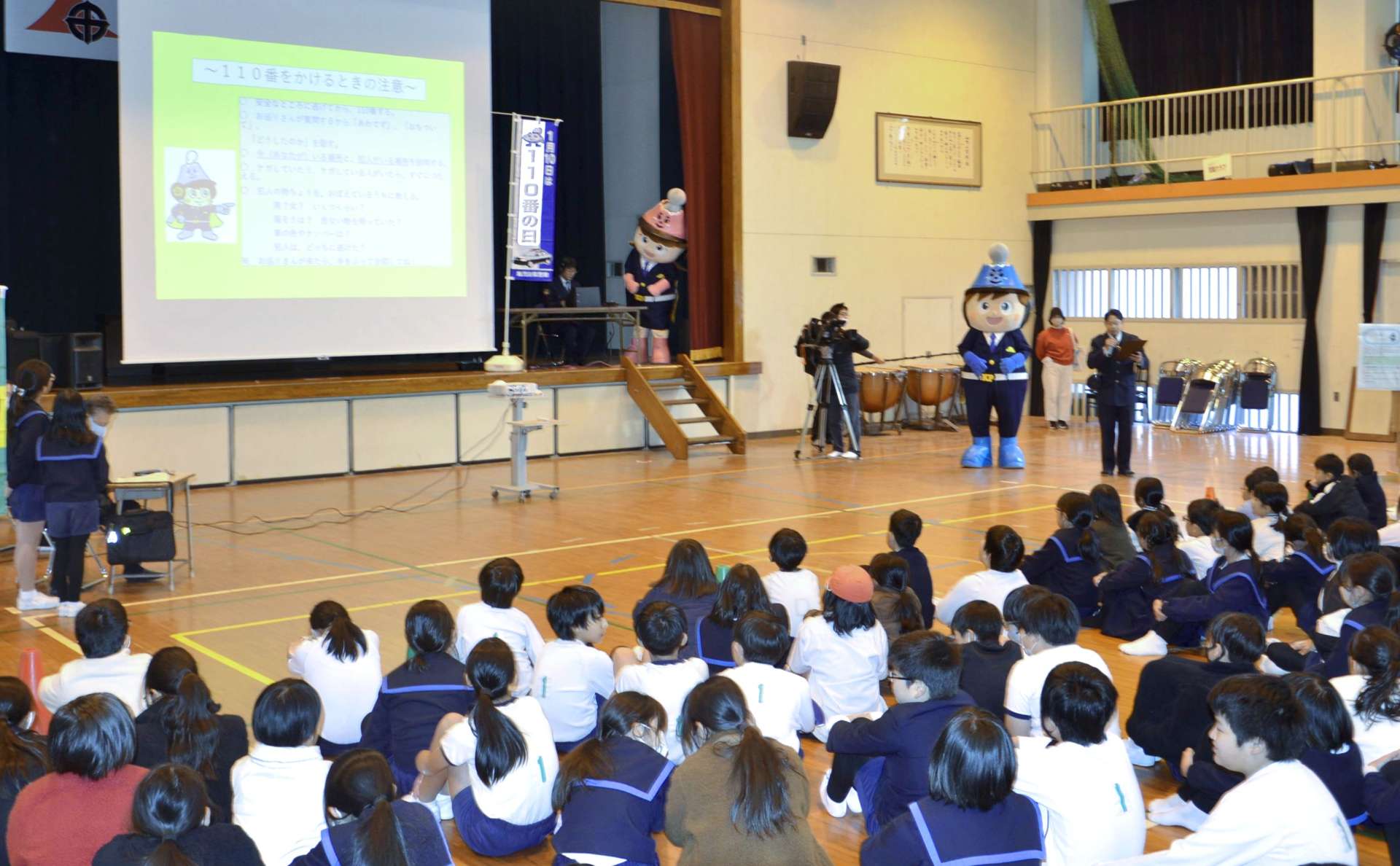 １１０番の正しい使い方を警察官に学ぶ児童＝１０日午後２時半ごろ、鹿児島市の山下小学校