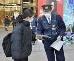 詐欺被害防止へチラシを配る警察官＝１０日午後、鹿児島市の鹿児島中央駅