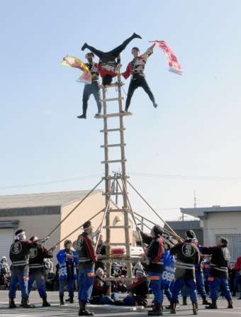 アクロバティックなはしごの演技を繰り広げる隊員ら＝指宿市の山川漁協