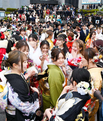 晴れ着姿で友人と談笑する「はたちの集い」の参加者＝１２日、鹿児島市の川商ホール