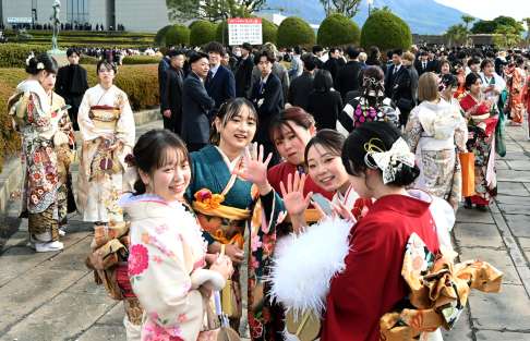 〈別カット〉晴れ着姿で友人と談笑する「はたちの集い」の参加者＝１２日、鹿児島市の川商ホール