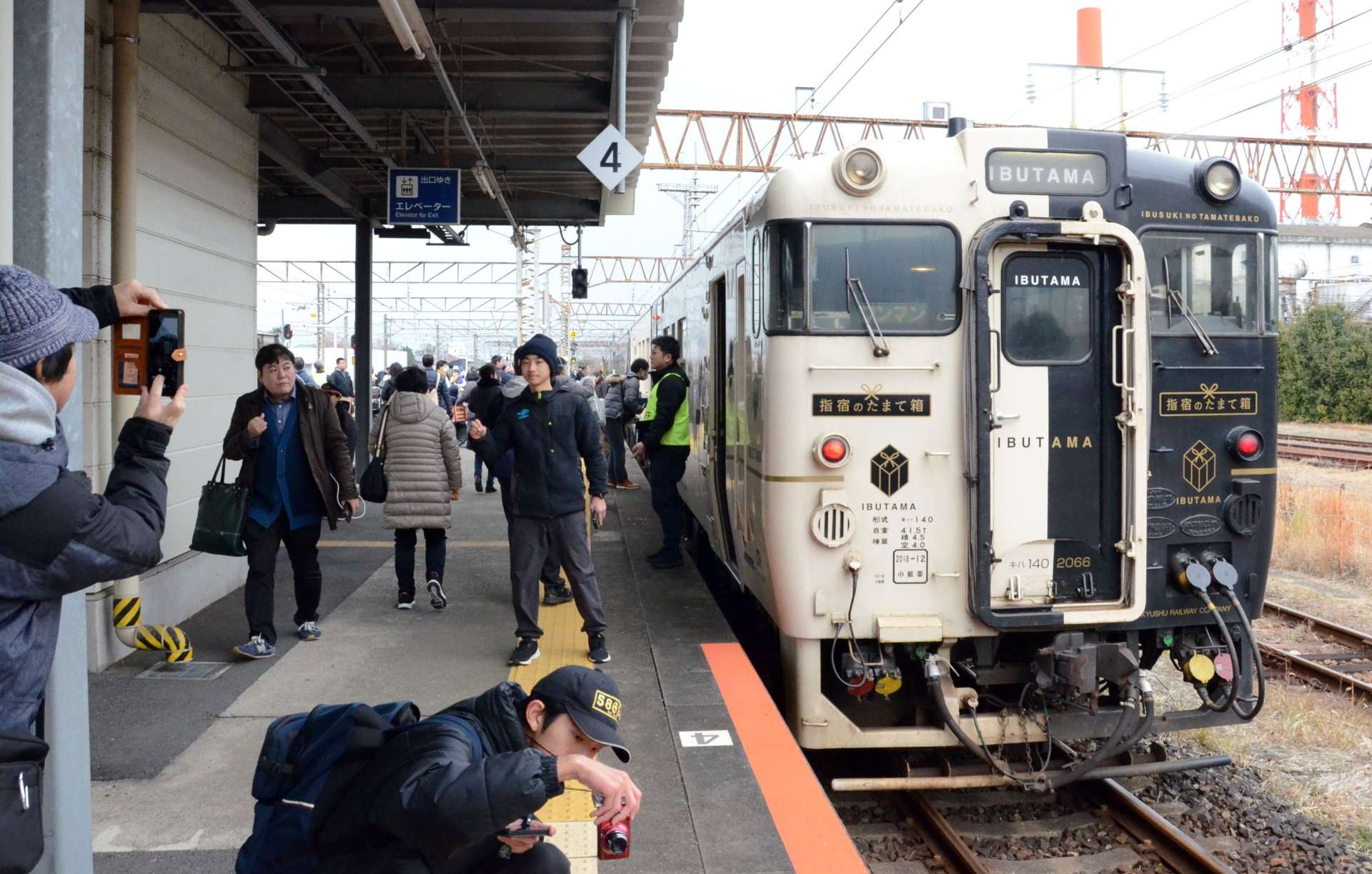 観光列車「指宿のたまて箱」と写真に納まる来場者ら＝１２日、熊本県八代市のＪＲ八代駅