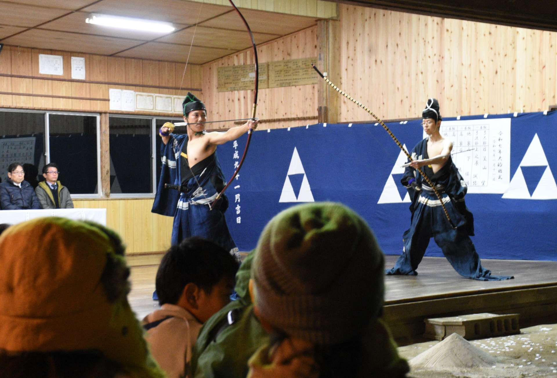 観客の目の前で的を狙う射手＝１１日夜、西之表市の栖林神社