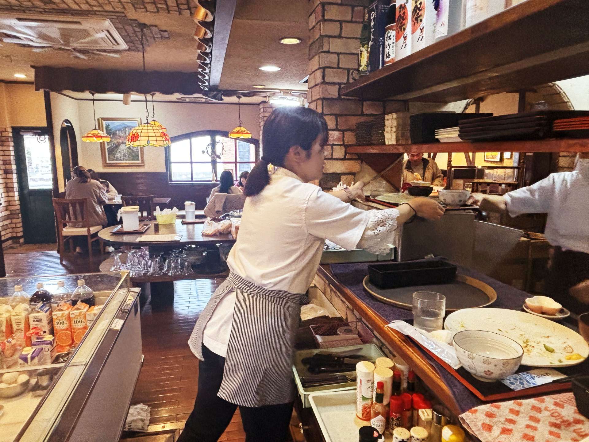 客が混み合う時間帯に店を手伝う記者＝９日、西之表市東町