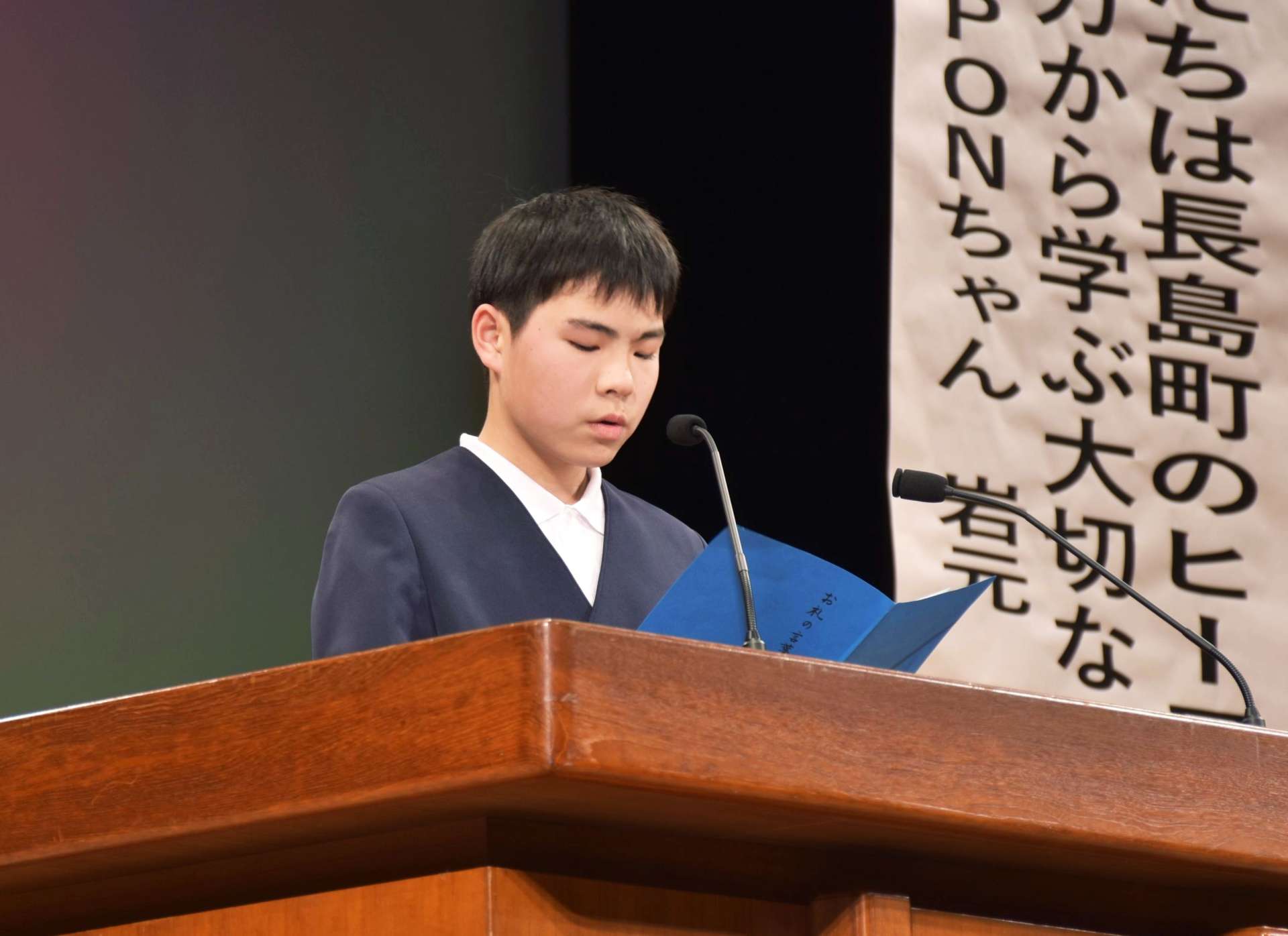 表彰を受けて感謝を述べる児童代表＝１１日、長島町文化センター